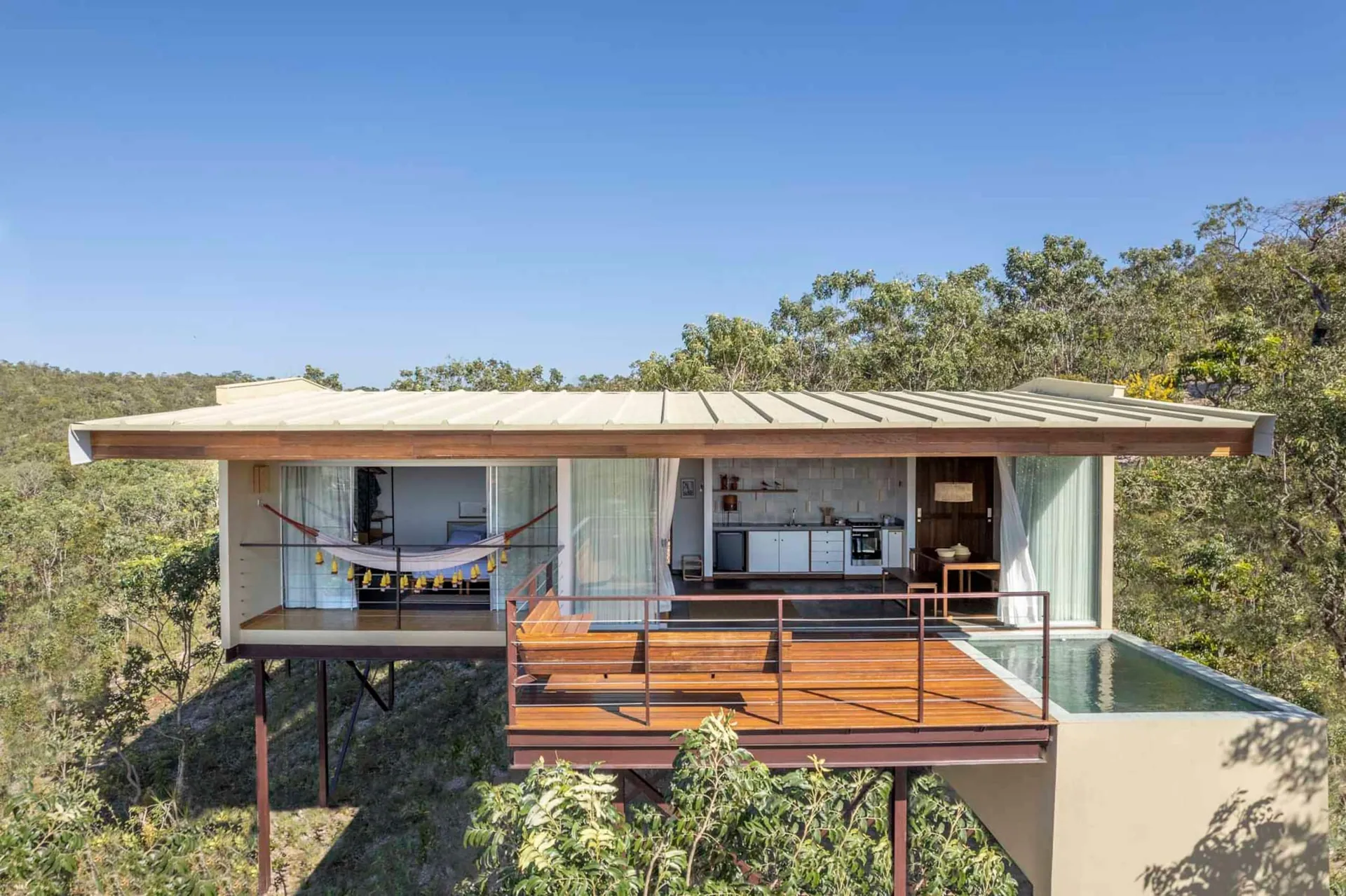 Casa Ipê sobre pilotis, com deck e piscina, em meio ao cerrado