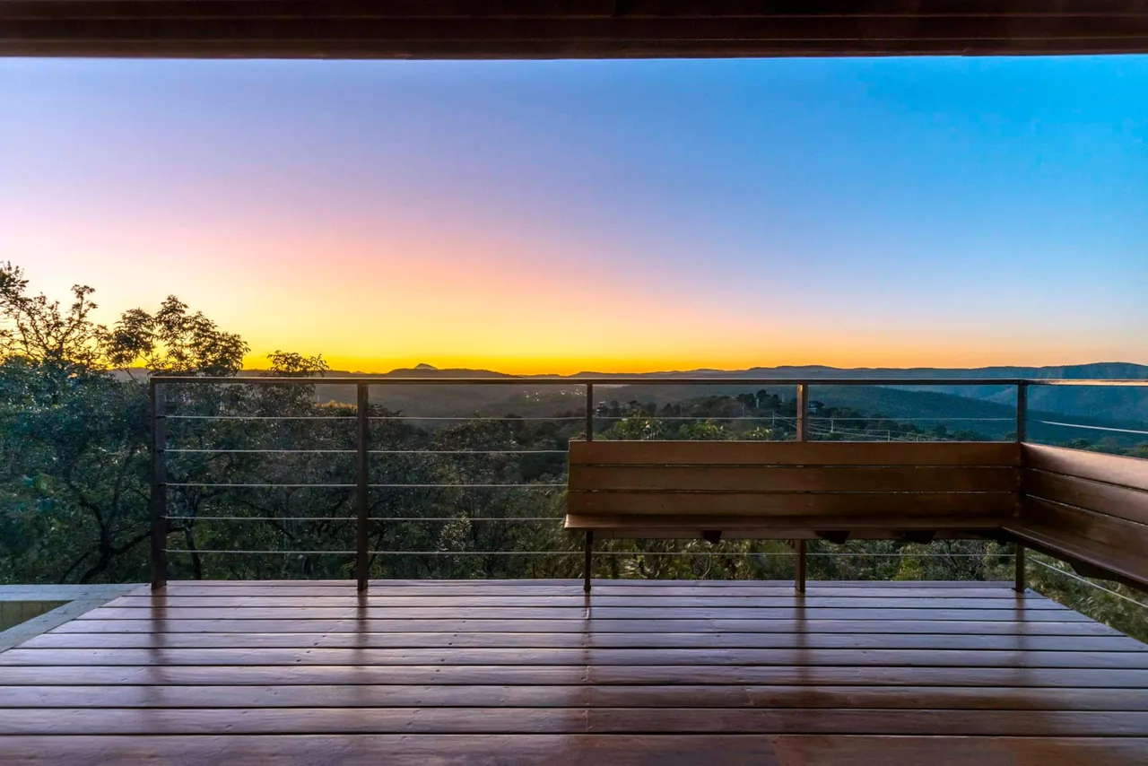 Deck da Casa Ipê com banco de madeira ao amanhecer