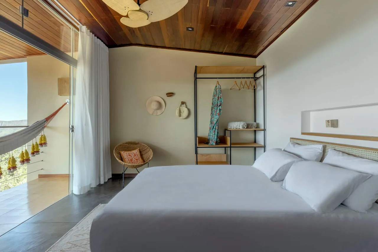 Suíte da Casa Ipê com cama queen e rede na varanda