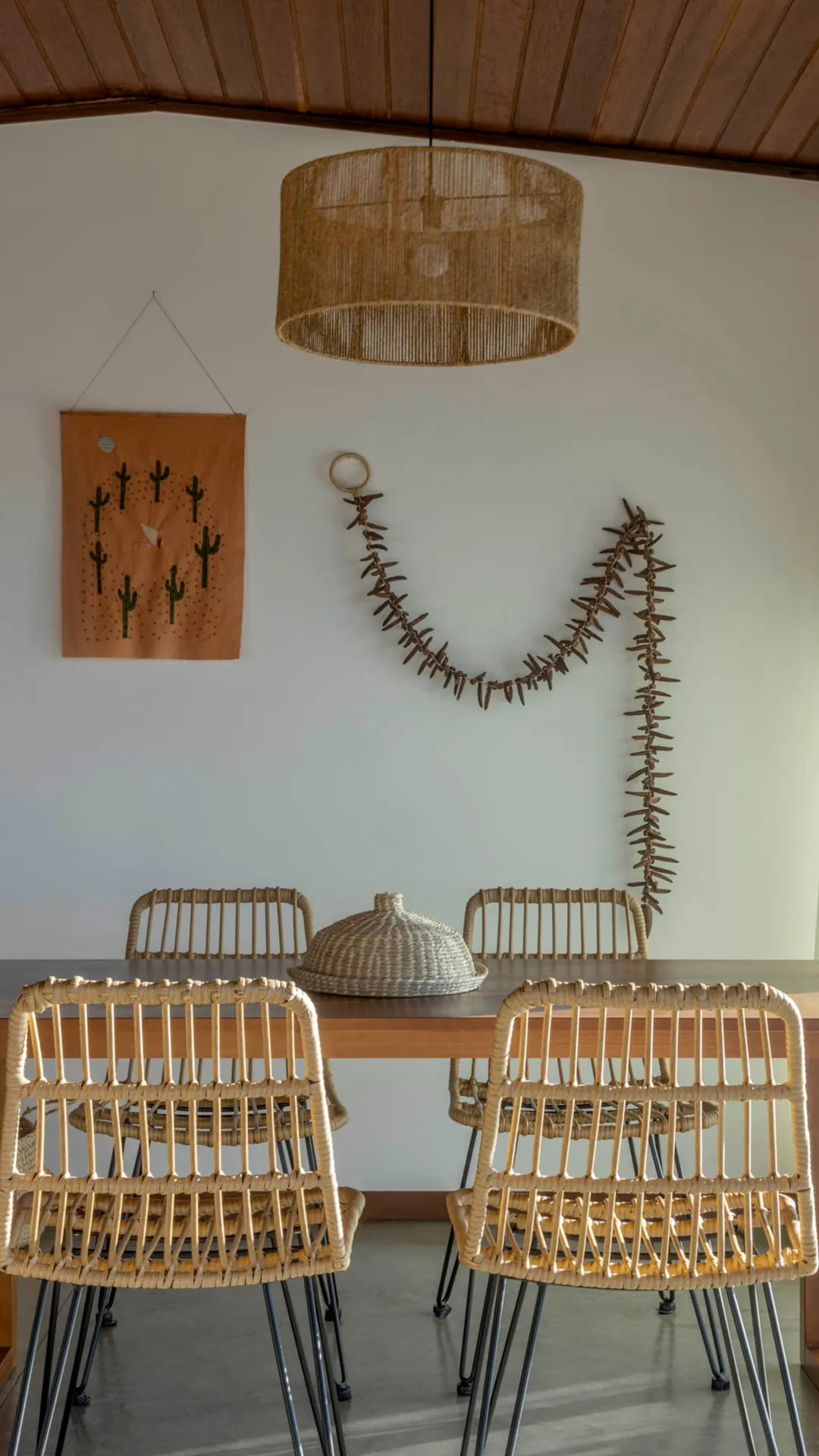 Mesa de jantar com cadeiras de fibra natural na Casa Jacarandá