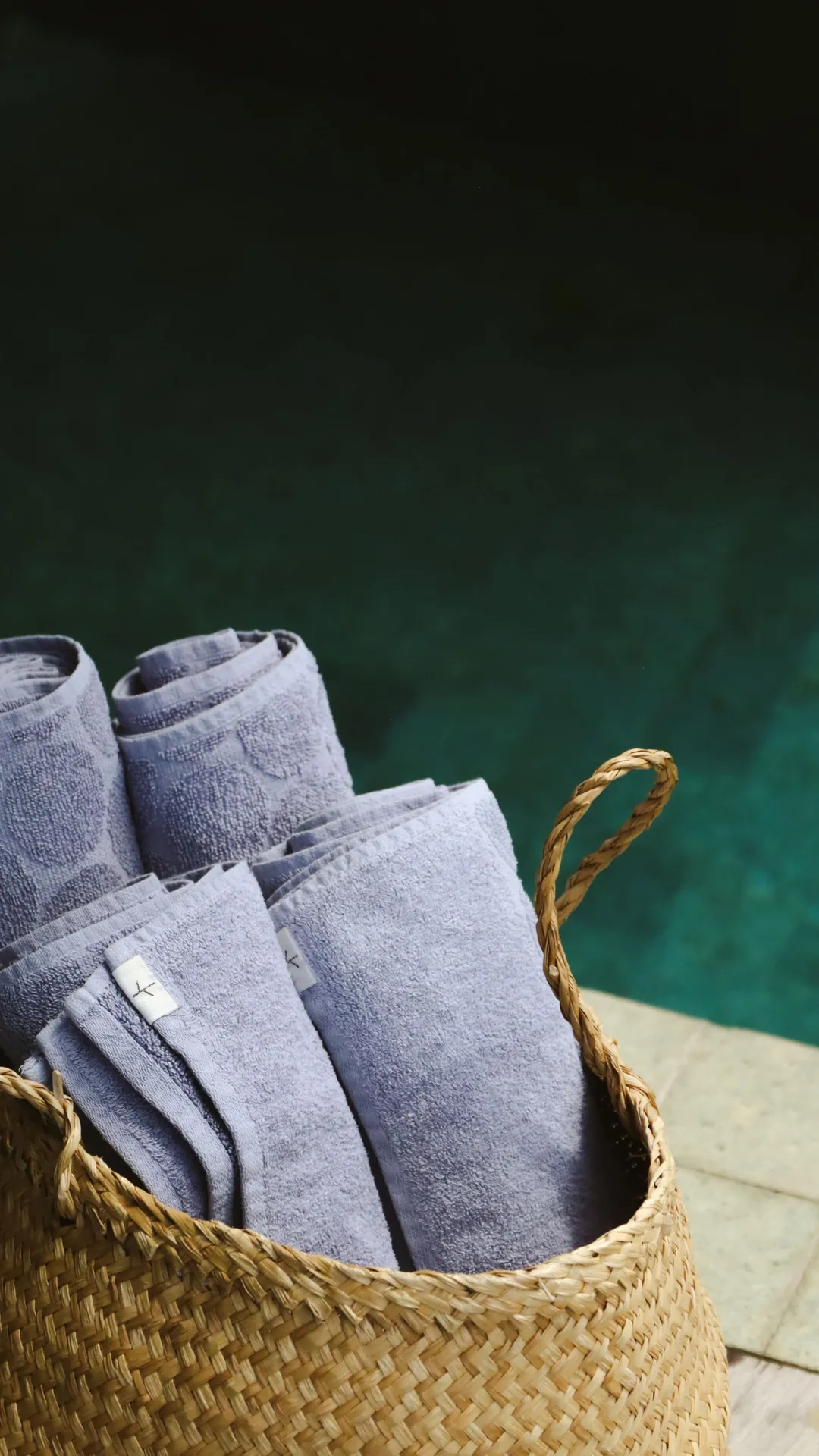 Cesto com toalhas à beira da piscina